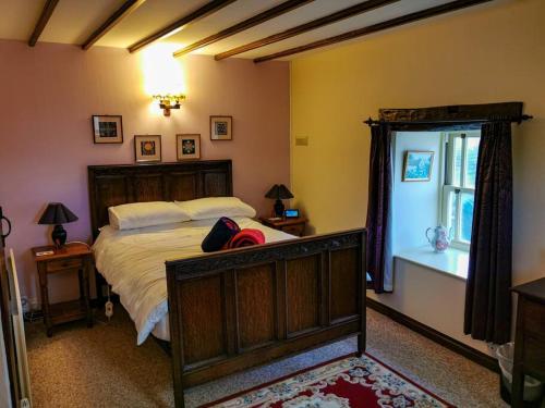 um quarto com uma cama grande e uma janela em Stonecroft Cottage em Middleham
