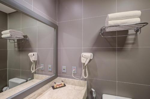 a bathroom with a sink and a mirror and a phone at Cyan Resort by Atlantica in Itupeva