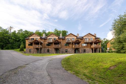 a large wooden house with a driveway at Mount Snow Lodging in Dover
