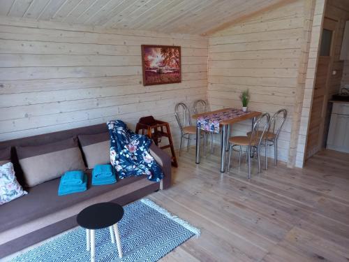 a living room with a couch and a table at Domki letniskowe Wczasy jak Marzenie in Ruciane-Nida