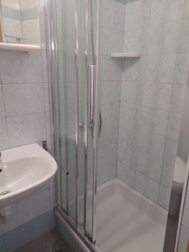 una ducha con una puerta de cristal junto a un lavabo en Rooms Mario en Cres