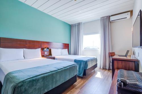 a hotel room with two beds and a window at Cyan Resort by Atlantica in Itupeva