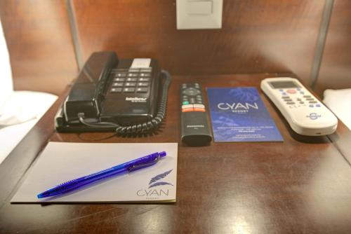 a desk with a pen and a phone and a book at Cyan Resort by Atlantica in Itupeva