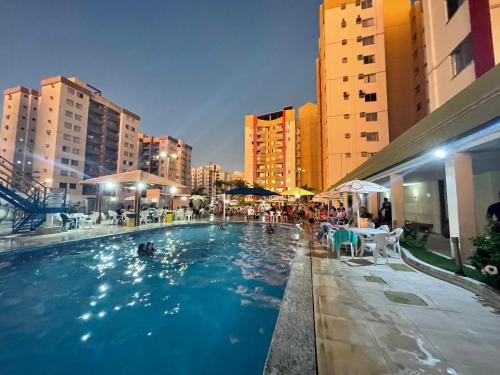 a swimming pool with tables and chairs and buildings at 905B -Residencial Privé das Thermas I- in Caldas Novas