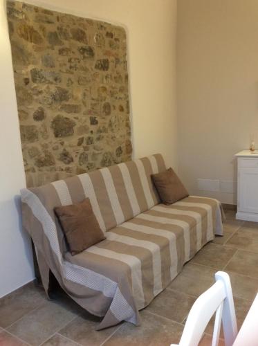 a couch in a room with a stone wall at Laura Chianti Vacanze in Poggibonsi