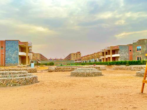 a group of rocks sitting in the sand in front of buildings at Chalet in La Jolie Marina El Ain El Sokhna - Egyptian Families Only in Ain Sokhna