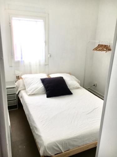- un lit avec un oreiller noir dans l'établissement Appartement T2 Carnon ouest/Palavas plage, à Palavas-les-Flots