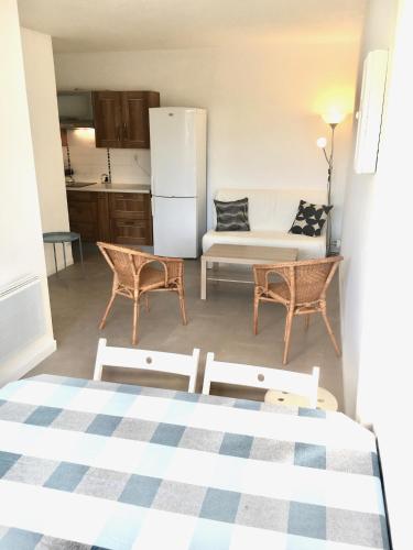 Il dispose d'une cuisine et d'un salon avec un canapé et des chaises. dans l'établissement Appartement T2 Carnon ouest/Palavas plage, à Palavas-les-Flots