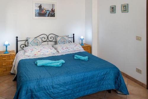 una camera da letto con un letto con due asciugamani blu sopra di Appartamento SEGESTA a Favignana