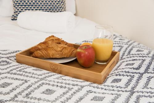a tray of food with an apple and a glass of orange juice at Lovely 2-bedroom Seaside Retreat with Free Parking in Great Yarmouth