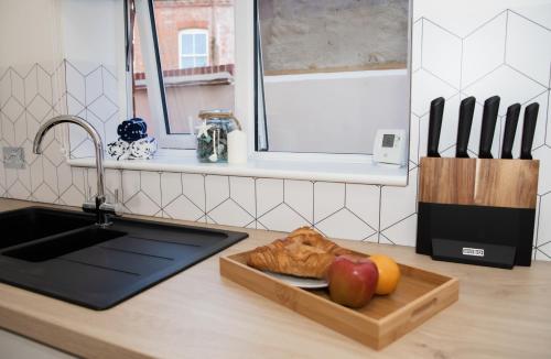 a kitchen counter with a sink and a cutting board with apples at Lovely 2-bedroom Seaside Retreat with Free Parking in Great Yarmouth