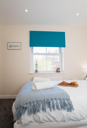 a bedroom with a bed with a blue window at Lovely 2-bedroom Seaside Retreat with Free Parking in Great Yarmouth