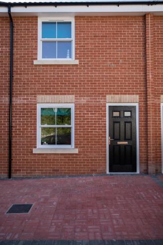 a brick building with two windows and a door at Lovely 2-bedroom Seaside Retreat with Free Parking in Great Yarmouth