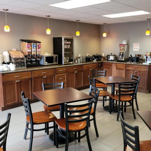 ein Restaurant mit Tischen und Stühlen und einer Küche in der Unterkunft Super 8 by Wyndham Heyburn in Burley