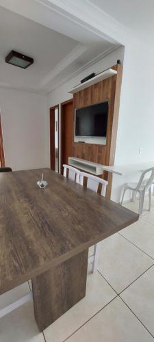 a large wooden table in a room with chairs at Apartamento Anna Carolina in Florianópolis