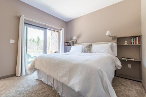 Un dormitorio con una gran cama blanca y una ventana en Spencertown Inn en Spencertown