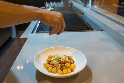 a person reaching for a bowl of food on a counter at Cyan Resort by Atlantica in Itupeva