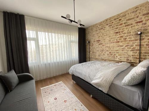 a bedroom with a brick wall and a bed and a couch at Galata VAV Suites in Istanbul