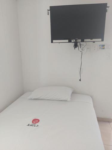 a white bed with a flat screen tv above it at EL ANCLA in Ciudad del Carmen