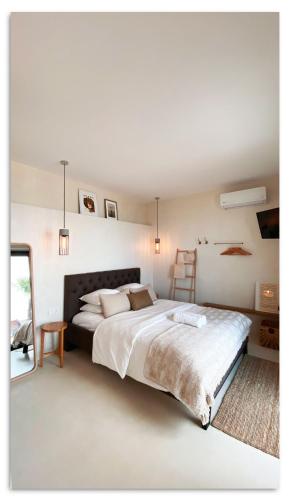 a white bedroom with a large bed and a ladder at Casa Del Mar Thassos in Skala Sotiros