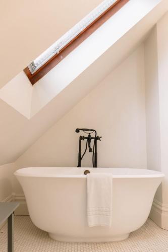 a bathroom with a white bath tub in the attic at The Grape Leaf Inn in Healdsburg