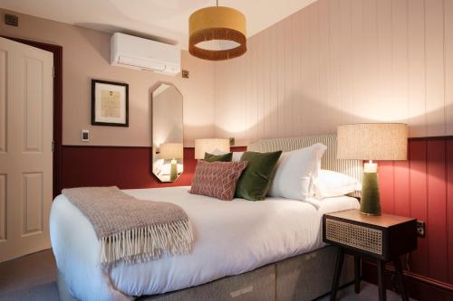 a bedroom with a large white bed with green pillows at The White Star Tavern in Southampton