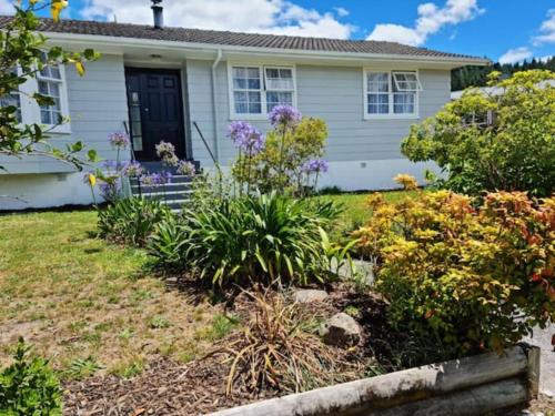 a house with flowers in the front yard at Gondola Views on Mallard in Rotorua