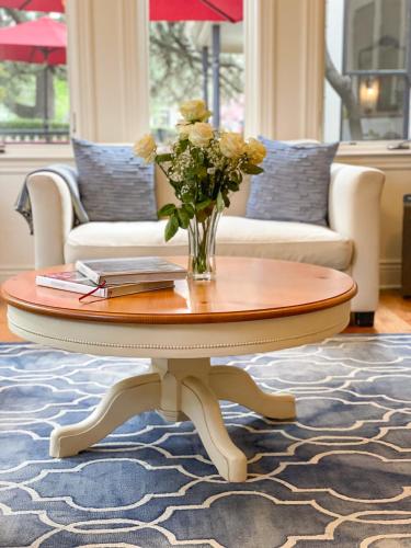 a coffee table with a vase of flowers on it at The Grape Leaf Inn in Healdsburg