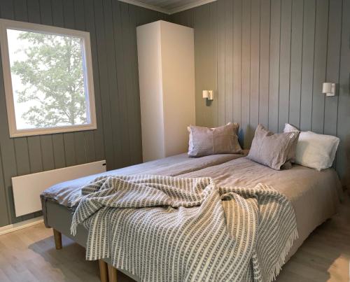 a bedroom with a large bed with a window at Brissundsbyn in Visby