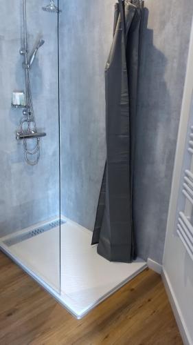 a shower stall with a glass door and a towel at Les loges in Parthenay
