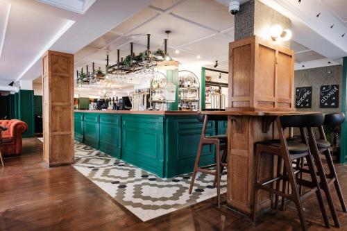 a bar with green cabinets and bar stools at The White Star Tavern in Southampton