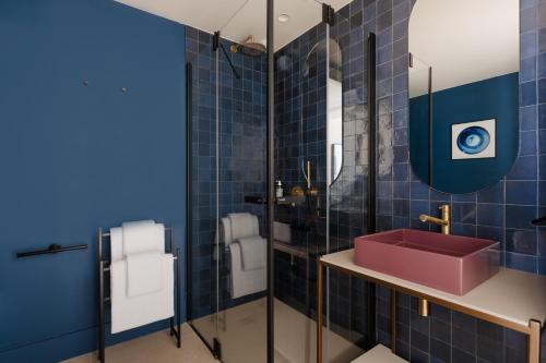 a bathroom with a red sink and blue tiles at Yelo Jean Médecin powered by Sonder in Nice