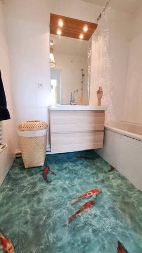 d'une salle de bains avec un sol contenant du poisson. dans l'établissement CAOPEO - Top Hôte Paris - 8 personnes Balcon Parking, à Saint-Denis