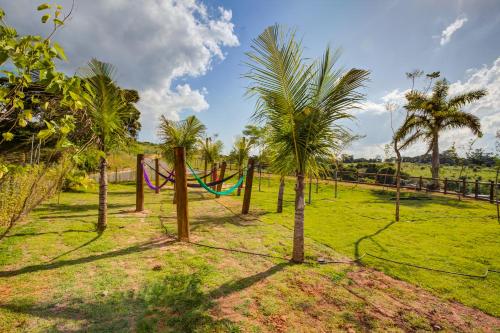 a hammock in a field with palm trees at Cyan Resort by Atlantica in Itupeva