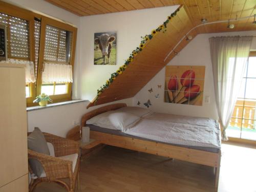 una camera con un letto in una stanza con finestre di Wehrlemartinshof a Simonswald
