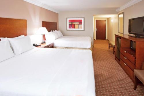 a hotel room with two beds and a flat screen tv at Holiday Inn Express & Suites Niagara Falls by IHG in Niagara Falls