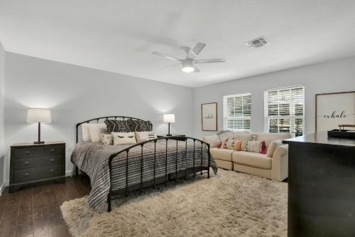 a bedroom with a bed and a couch at Wow! Haus with Hot Tub, Fire Pit and Games Galore! in Fredericksburg