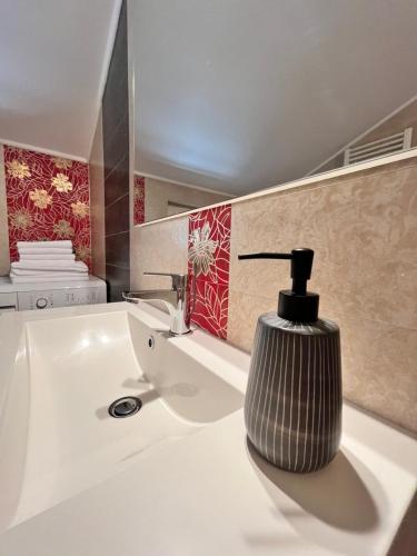 a bathroom sink with a soap dispenser on it at SKY - beautiful rooftop apartment with shared pool in Split