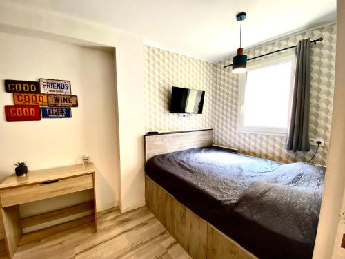 une chambre avec un lit et une télévision au mur dans l'établissement Bella Noche by D&O, à Carcassonne