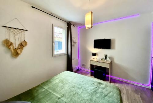 um quarto com uma cama verde e iluminação roxa em Drissia&Othman Bella Noche em Carcassonne