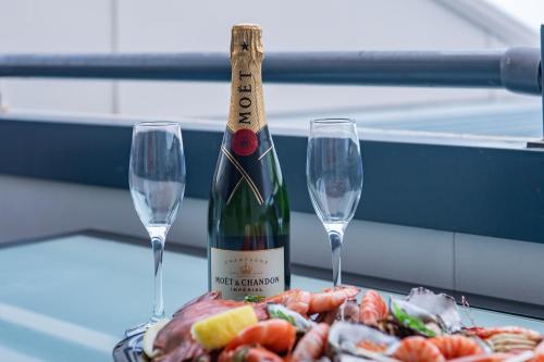 a bottle of wine and two glasses on a table at Ocean View Apartment 49 in Airlie Beach