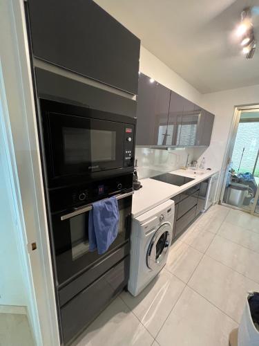 a kitchen with a washing machine and a microwave at Garden sea view - Victoria - Le Cannet in Le Cannet