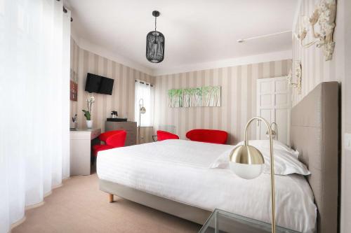 a bedroom with a white bed and red chairs at Best Western Brittany La Baule Centre in La Baule