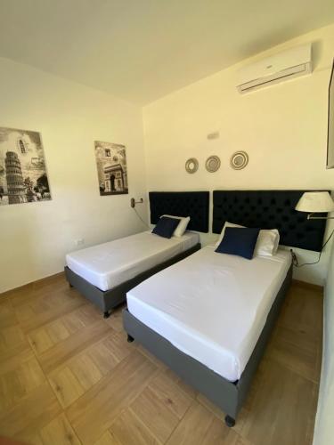 two beds in a hotel room with two beds at Hostal Palo Alto in San Andrés
