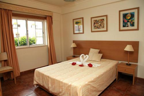 a bedroom with a bed with two roses on it at Alagoa Azul in Altura