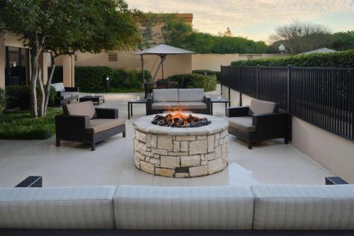 a fire pit in a patio with couches and chairs at Sonesta Select Dallas Central Expressway in Dallas