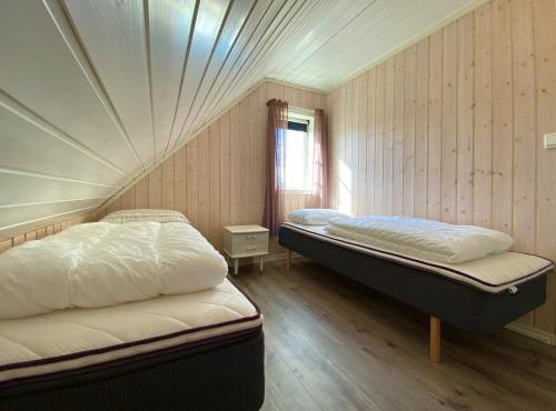 a bedroom with two beds and a window at Fishermans View in Alstad