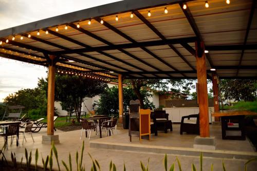 a wooden pergola with lights on a patio at ORIGEN FINCA HOTEL in Quimbaya