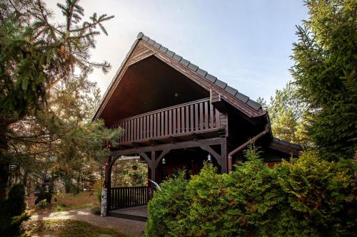 uma casa com um grande deque na floresta em Domek na Kaszubskiej z balią i kominkiem em Skoszewo