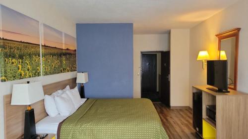 a hotel room with a bed and a television at Days Inn by Wyndham Topeka in Topeka